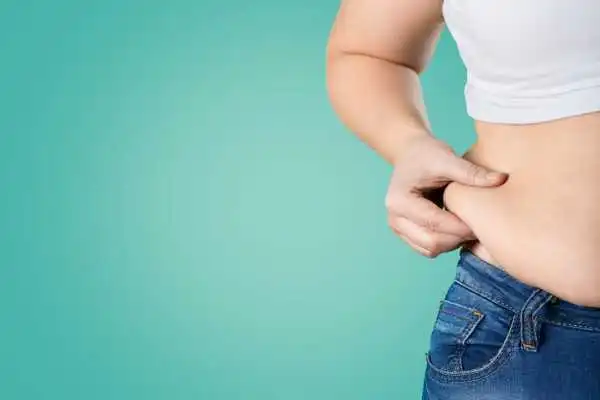 Image of woman pinching her love handles to show weight gain Newport
