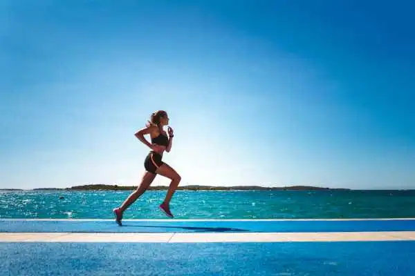 Woman running showing strong leg muscle Newport